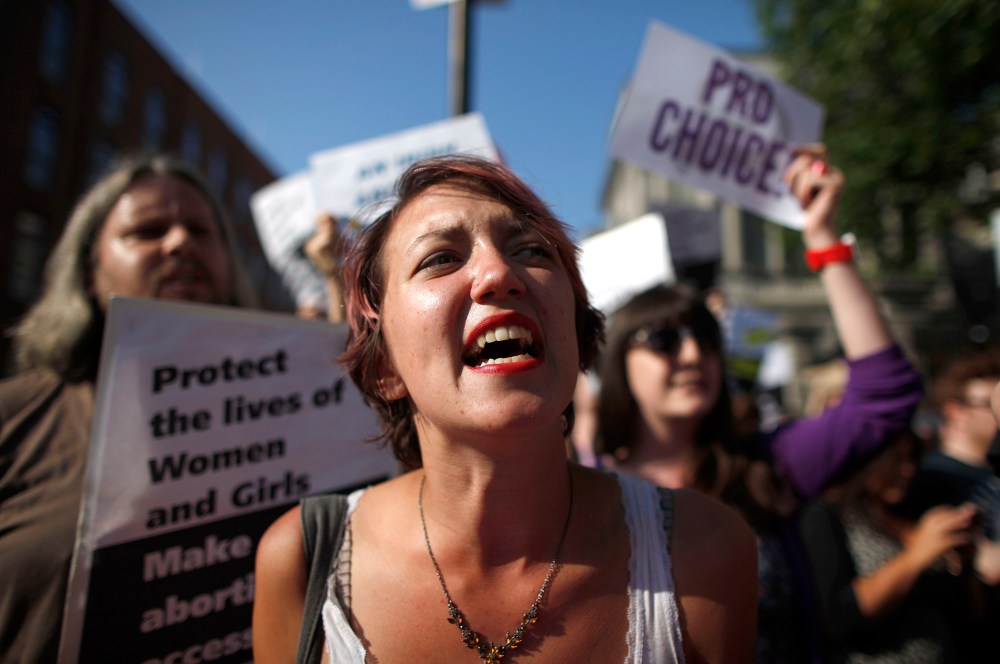 A Pro-Choice supporter holds placards in front of the gates of the Irish Parliament building in Dublin on July 10, 2013 ahead of a vote to introduce abortion in limited cases where the mother's life is at risk. (Photo by Peter Muhly/AFP/Getty)