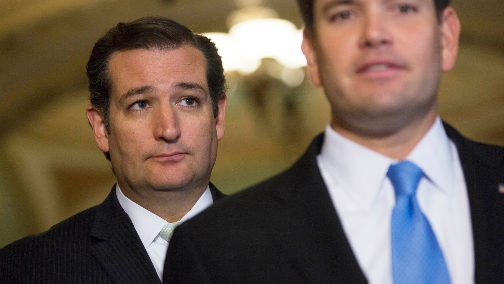 Senator Ted Cruz, a Republican from Texas, left, looks on as Senator Marco Rubio, a Republican from Florida, speaks during a news conference on Sept. 27, 2013. (Photo by Andrew Harrer/Bloomberg/Getty)