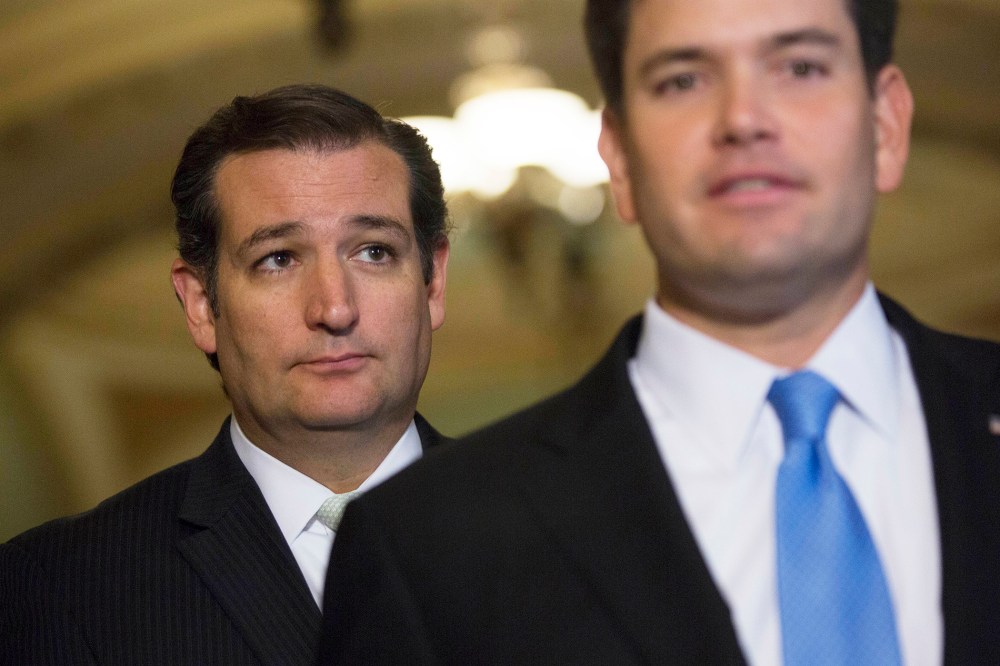 Senator Ted Cruz, a Republican from Texas, left, looks on as Senator Marco Rubio, a Republican from Florida, speaks during a news conference on Sept. 27, 2013. (Photo by Andrew Harrer/Bloomberg/Getty)