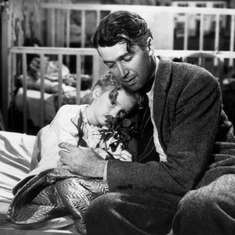 Actor James Stewart as George Bailey, hugs actor Karolyn Grimes, who plays Zuzu his daughter, in a still from director Frank Capra's Christmas classic film, 'It's a Wonderful Life'. (Photo by Hulton Archive/Getty)