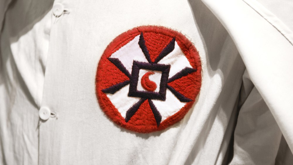 A photo illustration of a Ku Klux Klan member in white robe and hood. (Photo by Peter Dazeley/Getty)