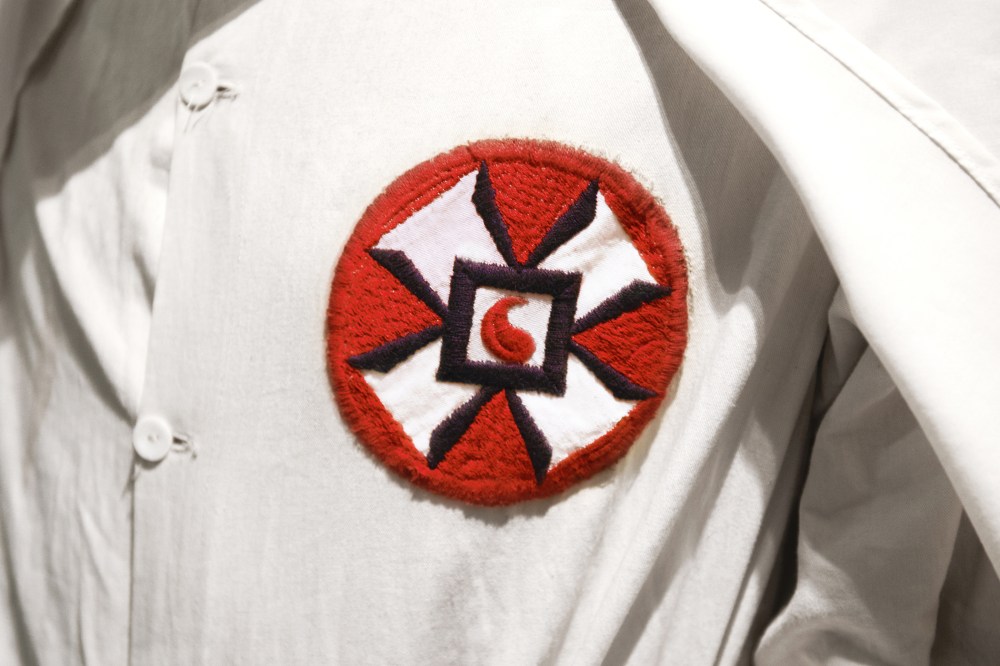 A photo illustration of a Ku Klux Klan member in white robe and hood. (Photo by Peter Dazeley/Getty)
