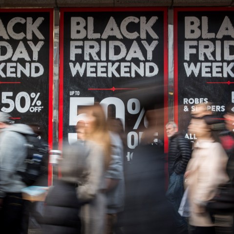 People walk past a shopfront advertising 'Black Friday' discounts on Nov. 28, 2014 in London, England. (Photo by Rob Stothard/Getty)