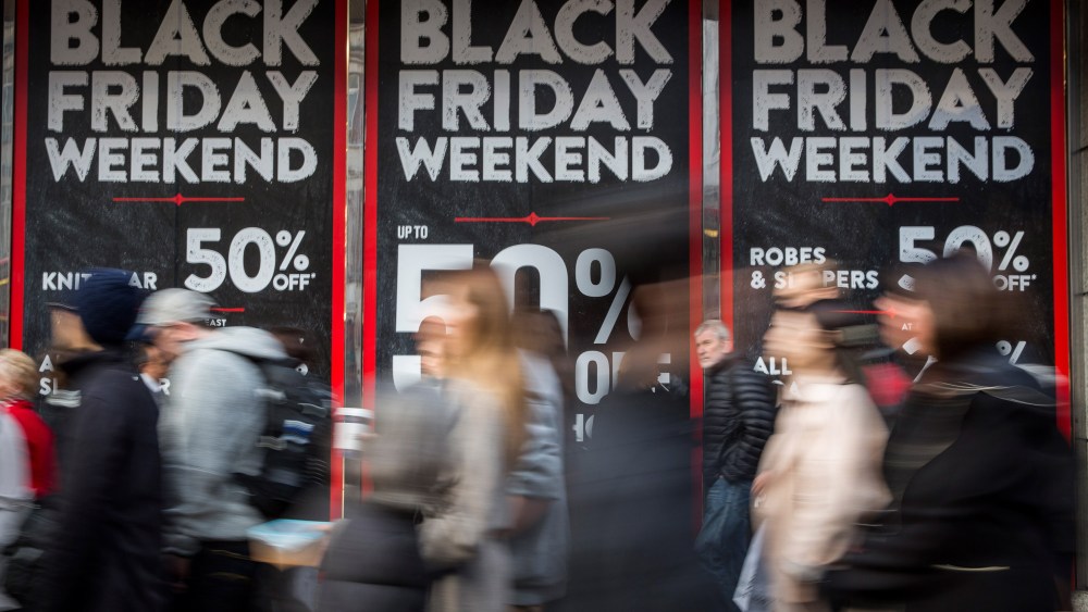 People walk past a shopfront advertising 'Black Friday' discounts on Nov. 28, 2014 in London, England. (Photo by Rob Stothard/Getty)