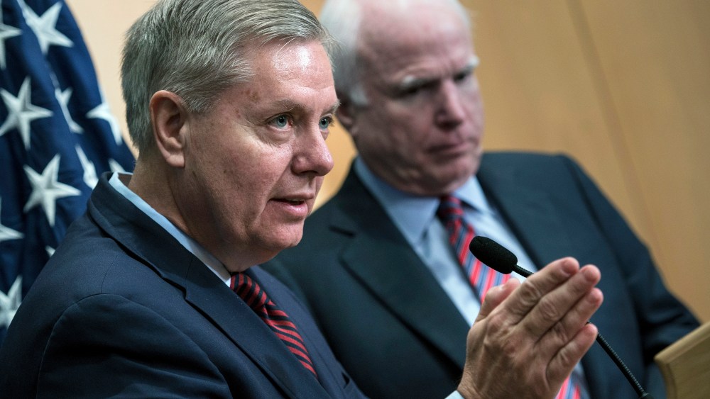 Senator Lindsey Graham speaks near Senator John McCain during a press conference at the David Citadel hotel on Jan. 3, 2014. (Photo by Brendan Smialowski/AFP/Getty)