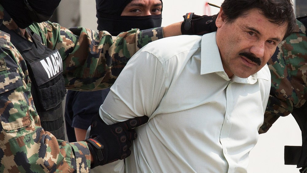 Drug trafficker Joaquin "El Chapo" Guzman is escorted to a helicopter by Mexican security forces at Mexico's International Airport in Mexico city, Mexico on Feb. 22, 2014. (Photo by Susana Gonzalez/Bloomberg/Getty)