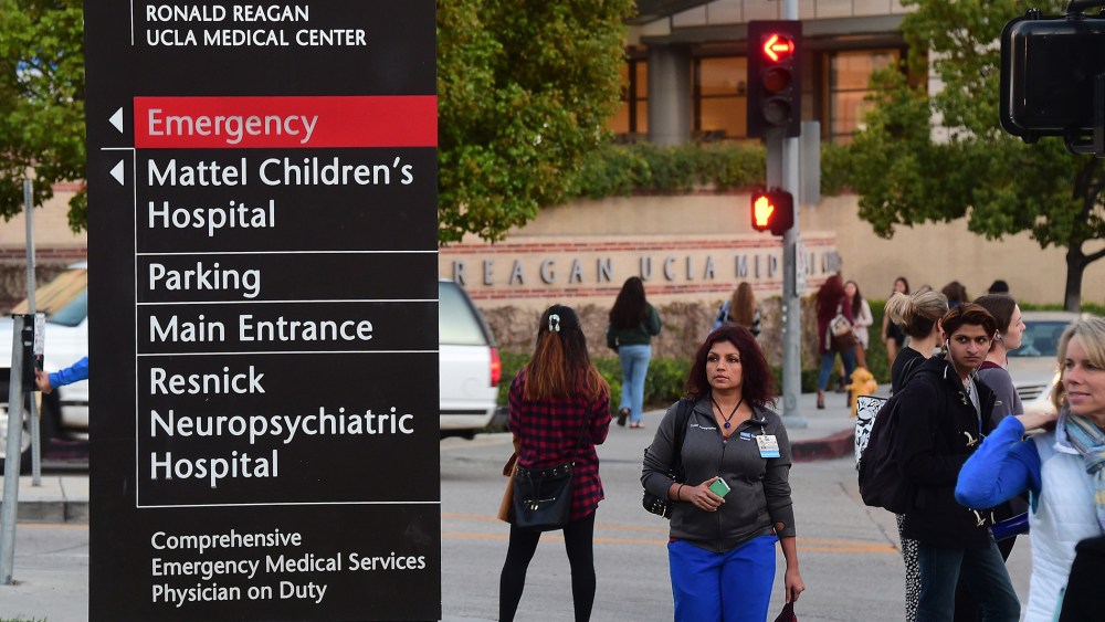 Pedestrians and students watch media gathered outside the Ronald Reagan UCLA Medical Center in Los Angeles, Calif. on March 5, 2015. (Photo by Frederic J. Brown/AFP/Getty)