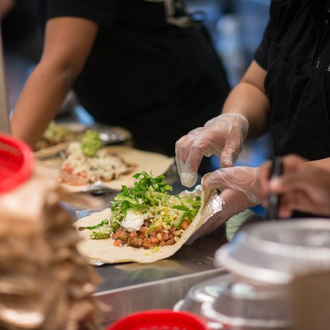 Employees prepare lunch orders at a Chipotle Mexican Grill restaurant. (Photo by Craig Warga/Bloomberg/Getty)