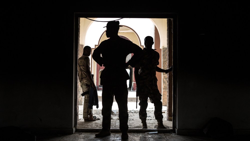 Nigerian troops inspect the former emir's palace that was used by Boko Haram as their headquarters but was burnt down when they fled Bama on March 25, 2015. (Photo by Nichole Sobecki/AFP/Getty)