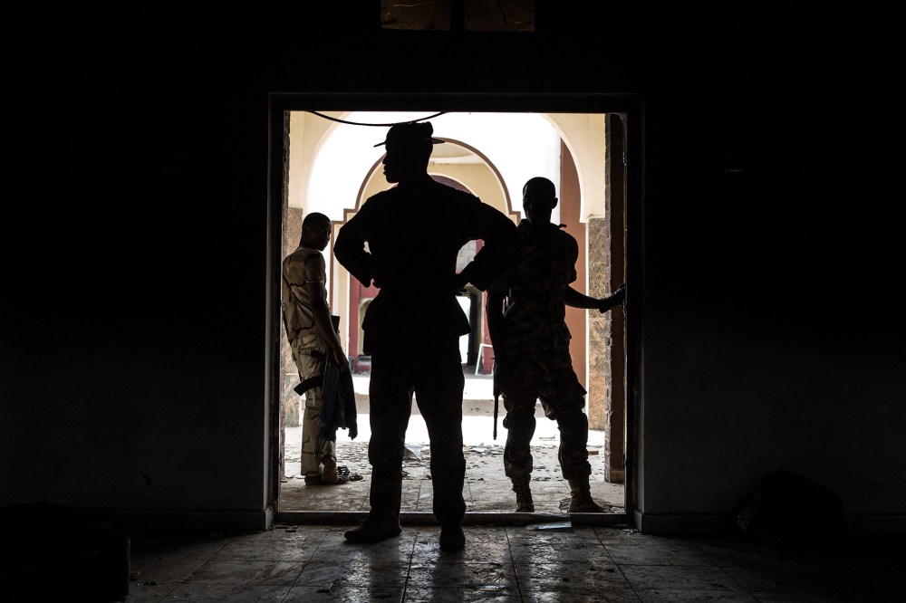 Nigerian troops inspect the former emir's palace that was used by Boko Haram as their headquarters but was burnt down when they fled Bama on March 25, 2015. (Photo by Nichole Sobecki/AFP/Getty)