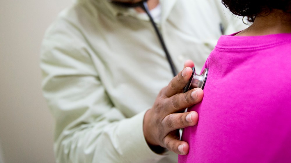 A family practice provider uses a stethoscope to examine a patient in an exam room. (Photo by Andrew Harrer/Bloomberg/Getty)
