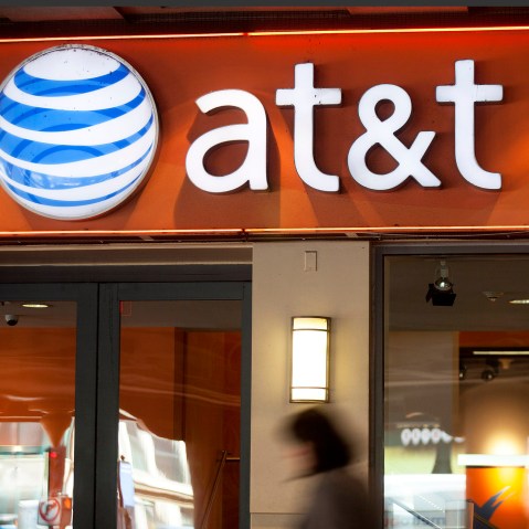 Pedestrians walk past an AT&T store in Washington, D.C. (Photo by Andrew Harrer/Bloomberg/Getty)
