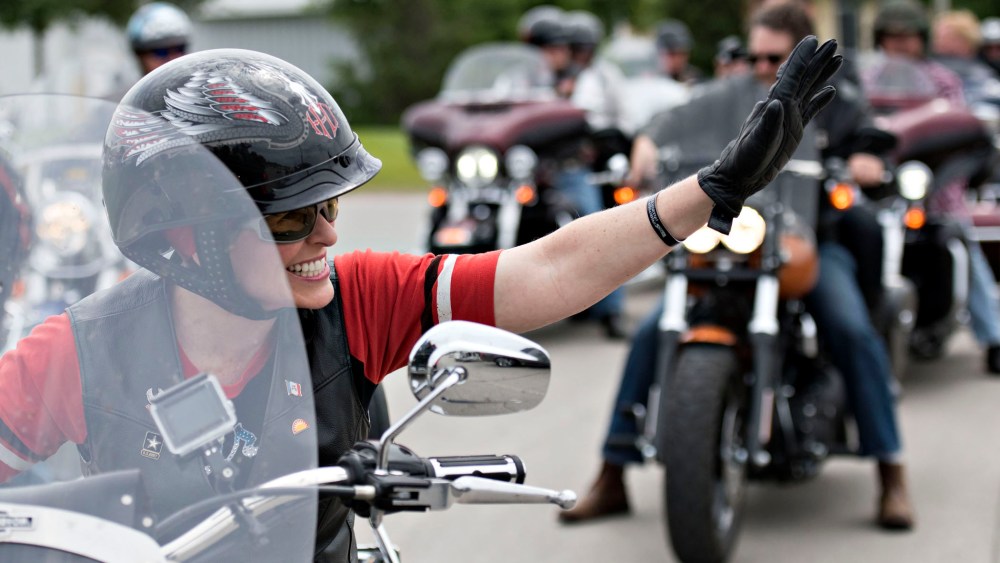 Senator Joni Ernst, a Republican from Iowa, waves to supporters as she rides the lead bike in a group motorcycle ride in Des Moines, Iowa on June 6, 2015. (Photo by Daniel Acker/Bloomberg/Getty)