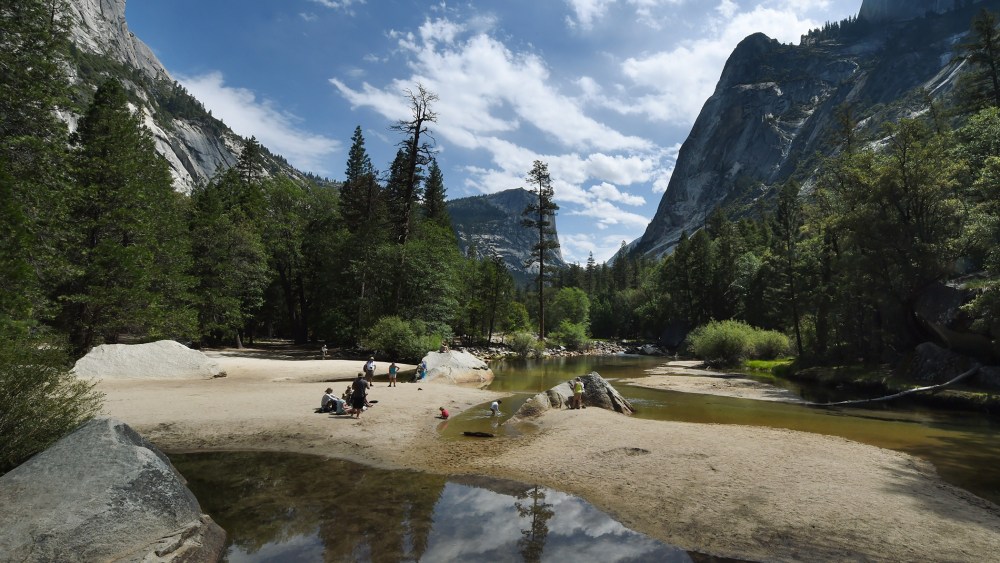 People picnic on the exposed sandy bottom of Mirror Lake that is normally underwater and used by visitors to photograph reflections of the Half Dome rock monolith, June 4, 2015, at Yosemite National Park in Calif. (Photo by Mark Ralston/AFP/Getty)