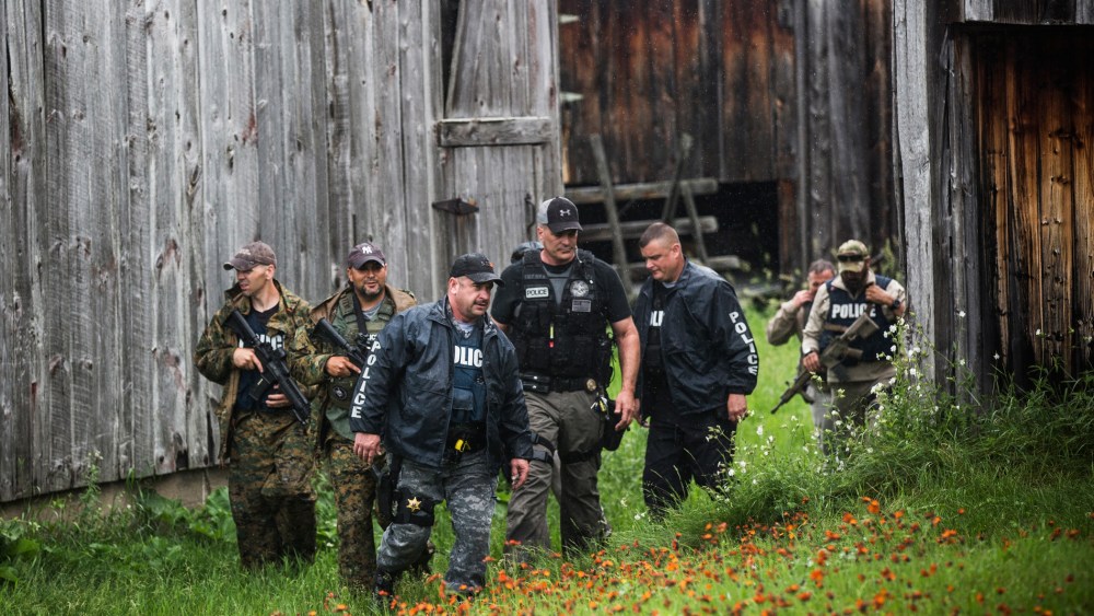 A task force of U.S. Marshalls and police officers go door to door searching for two escaped convicts on June 16, 2015 outside Dannemora, N.Y. (Photo by Andrew Burton/Getty)