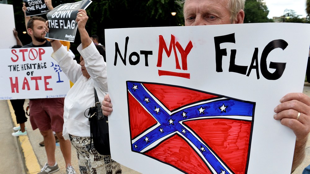 A man holds a sign up during a protest rally against the Confederate flag in Columbia, S.C., June 20, 2015. (Photo by Mladen Antonov/AFP/Getty)