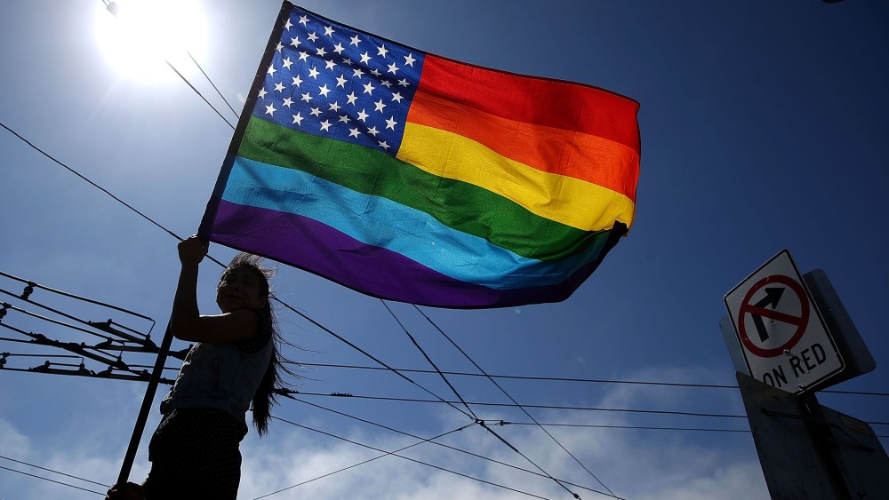 A same-sex marriage supporter waves a pride flag (Photo by Justin Sullivan/Getty).