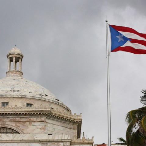 The Puerto Rican flag flies near the Capitol building as the island's residents deal with the government's $72 billion debt on July 1, 2015 in San Juan, Puerto Rico. (Photo by Joe Raedle/Getty)
