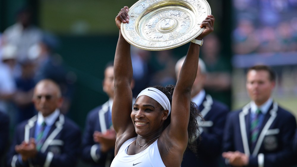 US player Serena Williams celebrates with the winner's trophy, the Venus Rosewater Dish, after her women's singles final victory over Spain's Garbine Muguruza during the 2015 Wimbledon Championships on July 11, 2015. (Photo by Glyn Kirk/AFP/Getty)