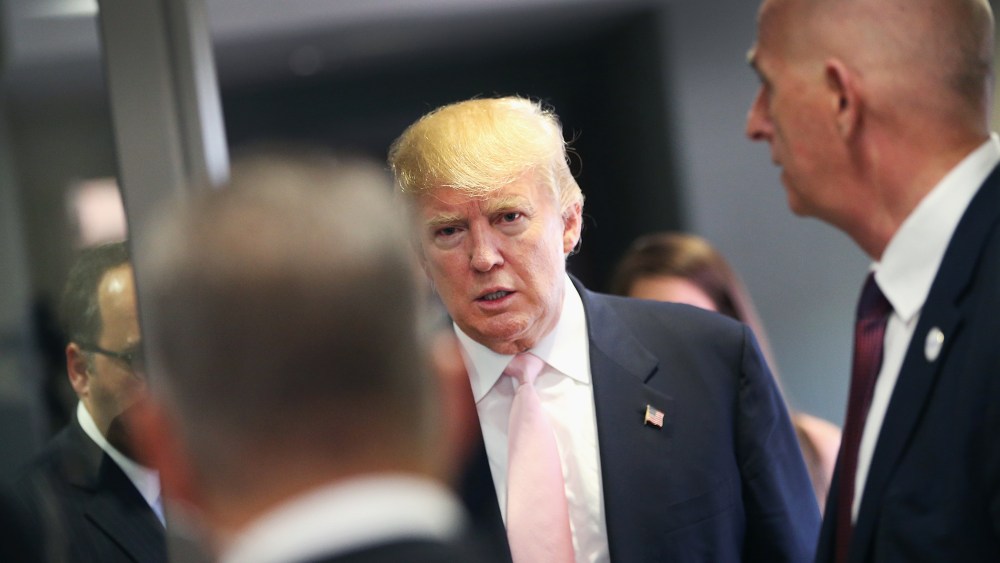 A security team stands guard as Republican presidential hopeful businessman Donald Trump speaks heads to a press conference following a rally on July 25, 2015 in Oskaloosa, Iowa. (Photo by Scott Olson/Getty)