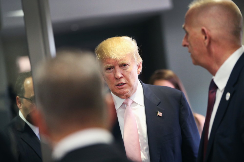 A security team stands guard as Republican presidential hopeful businessman Donald Trump speaks heads to a press conference following a rally on July 25, 2015 in Oskaloosa, Iowa. (Photo by Scott Olson/Getty)