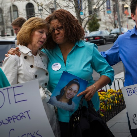 Relatives of victims of notable shootings comfort one another during a protest outside the National Shooting Sports Foundation's annual Congressional Fly-In fundraising dinner April 2, 2014, in Washington, DC. (Photo by Rod Lamkey/Getty)