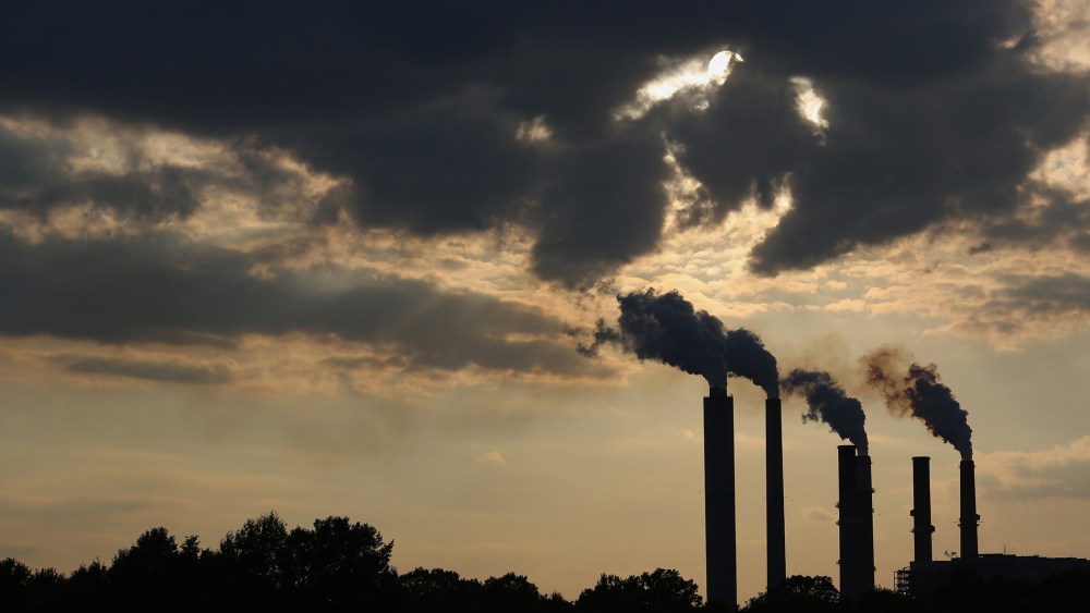 The silhouettes of emissions are seen rising from stacks of the Duke Energy Corp. Gibson Station power plant at dusk in Indiana, July 23, 2015. (Photo by Luke Sharrett/Bloomberg/Getty)