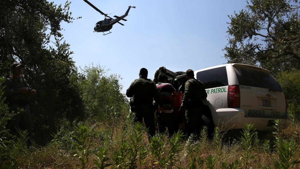 U.S. Border Patrol agents detain undocumented immigrants north of the U.S.-Mexico border on Aug. 6, 2015 near Falfurrias, Texas. (Photo by John Moore/Getty)