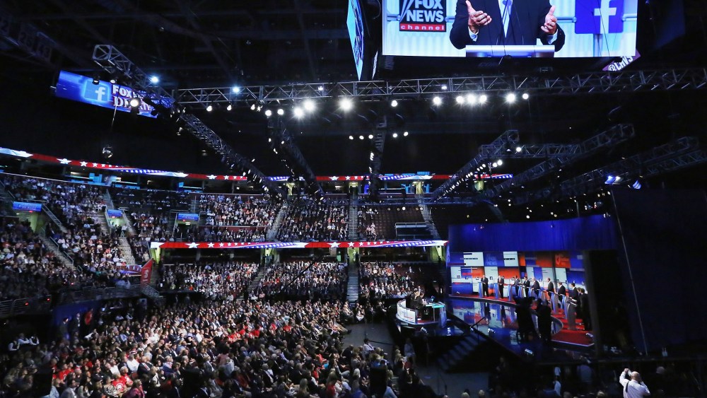 Republican presidential candidate Wisconsin Gov. Scott Walker appears on the screen hanging above the debate at the Quicken Loans Arena August 6, 2015 in Cleveland, Ohio. (Photo by Chip Somodevilla/Getty)