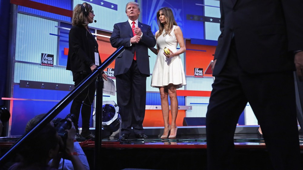 Republican presidential candidate Donald Trump (C) and his wife Melania Trump stand on the stage after the first prime-time presidential debate on Aug. 6, 2015 in Cleveland, Ohio. (Photo by Chip Somodevilla/Getty)