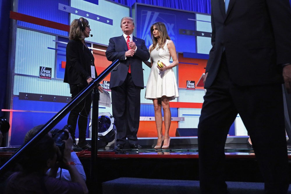 Republican presidential candidate Donald Trump (C) and his wife Melania Trump stand on the stage after the first prime-time presidential debate on Aug. 6, 2015 in Cleveland, Ohio. (Photo by Chip Somodevilla/Getty)