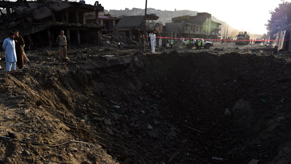 Afghan security forces and residents stand near the crater from a powerful truck bomb in Kabul on Aug. 7, 2015. (Photo by Wakil Kohsar/AFP/Getty)