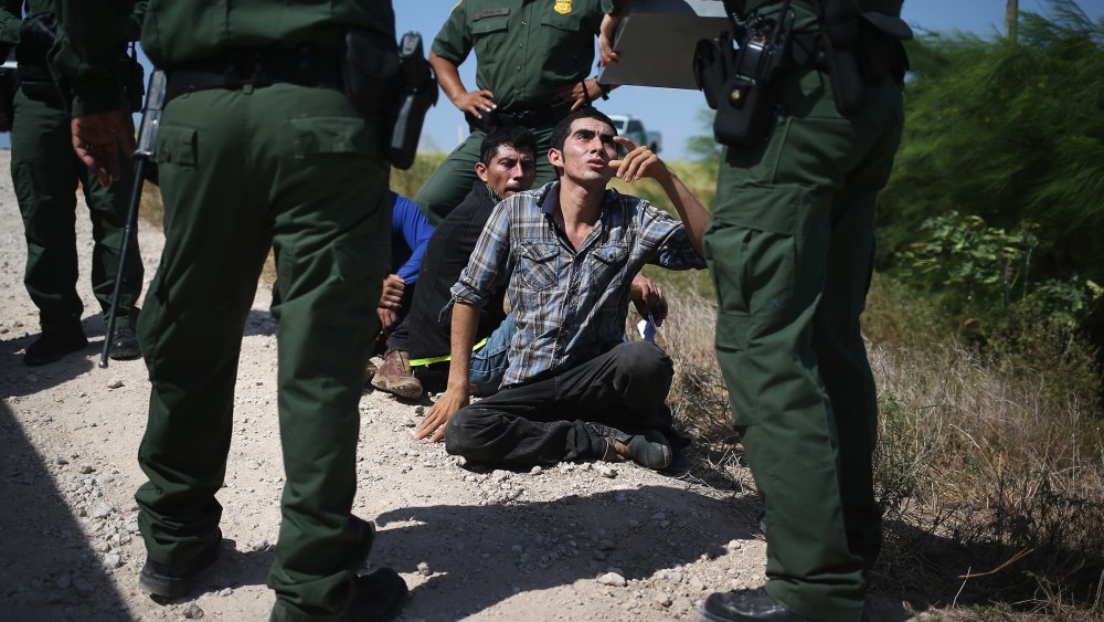 U.S. Border Patrol agents detain undocumented immigrants after they crossed the border from Mexico into the United States on Aug. 7, 2015 in McAllen, Texas. (Photo by John Moore/Getty)