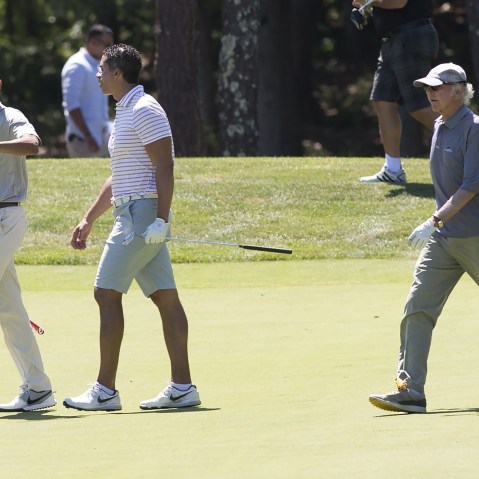 U.S. President Barack Obama walks alongside Cyrus Walker and comedian Larry David as they play golf at Farm Neck Golf Club in Oak Bluffs on Martha's Vineyard, Mass., Aug. 8, 2015. (Photo by Saul Loeb/AFP/Getty)
