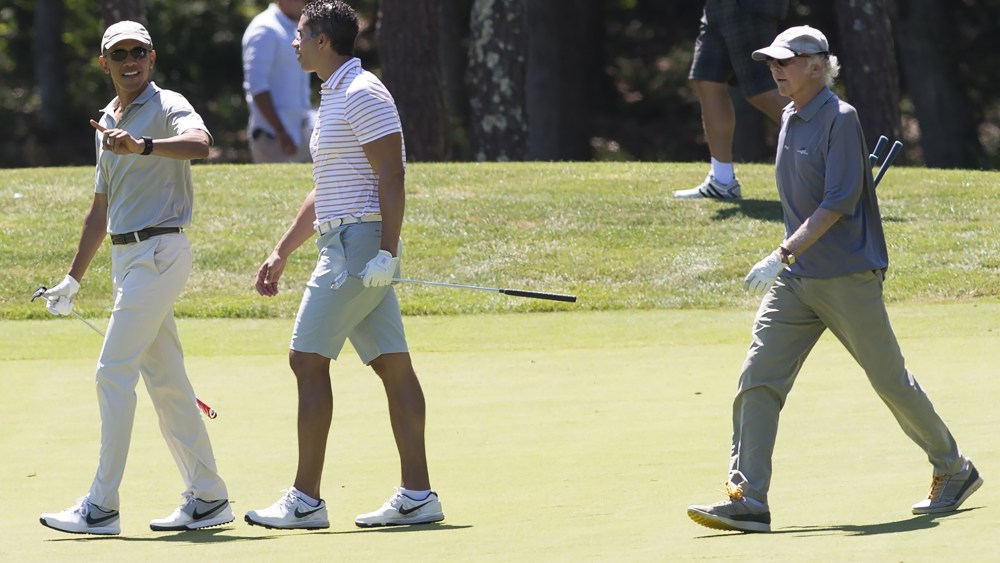 U.S. President Barack Obama walks alongside Cyrus Walker and comedian Larry David as they play golf at Farm Neck Golf Club in Oak Bluffs on Martha's Vineyard, Mass., Aug. 8, 2015. (Photo by Saul Loeb/AFP/Getty)