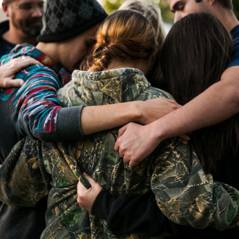 Friends of the late Rebecka Ann Carnes, an Umpqua Community College mass shootings victim, embrace one another in prayer during a memorial service in Winston, Ore., Oct. 3, 2015. (Photo by Marcus Yam/Los Angeles Times/Getty)