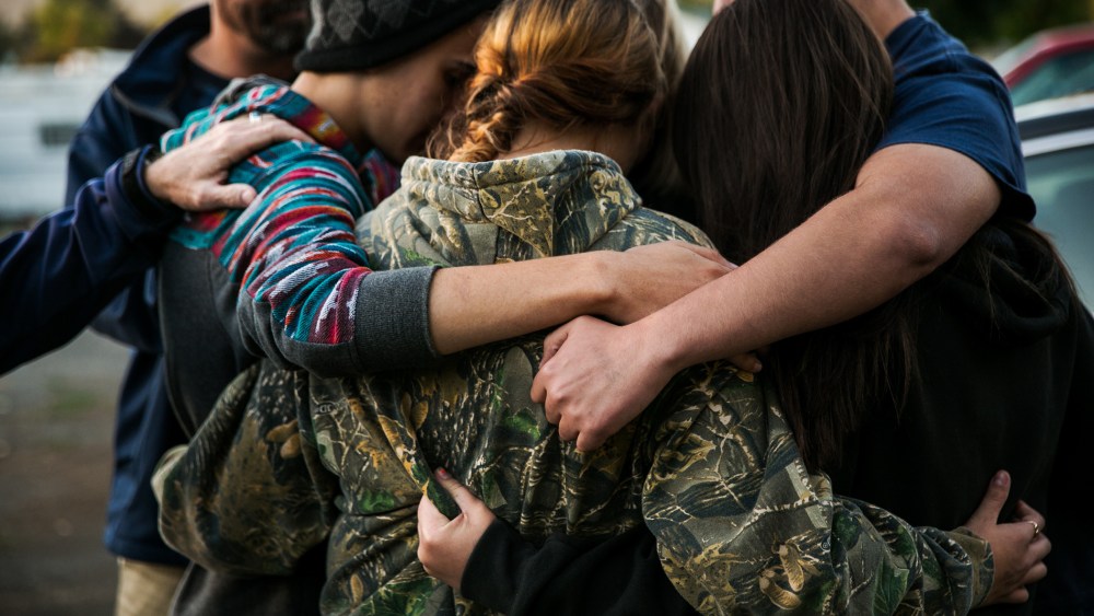 Friends of the late Rebecka Ann Carnes, an Umpqua Community College mass shootings victim, embrace one another in prayer during a memorial service in Winston, Ore., Oct. 3, 2015. (Photo by Marcus Yam/Los Angeles Times/Getty)