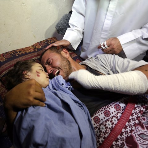 Palestinian father Yehya Hasan mourns while holding the body of his daughter, Rahaf, during a funeral for the toddler and her pregnant mother on Oct. 11, 2015, at the al-Nusairat refugee camp, in central Gaza Strip. (Photo by Mahmud Hams/AFP/Getty)
