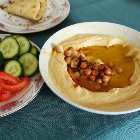 Plates of hummus, fresh vegetables and home-made bread. (Photo by Sean Gallup/Getty)