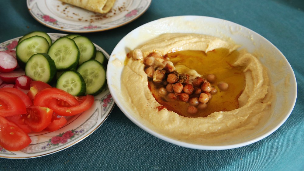Plates of hummus, fresh vegetables and home-made bread. (Photo by Sean Gallup/Getty)