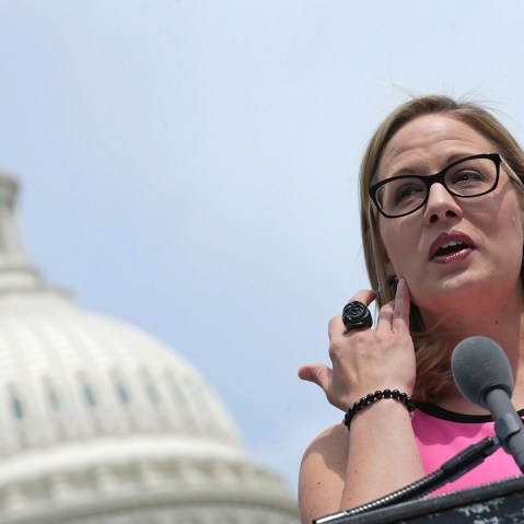 Rep. Kyrsten Sinema (D-AZ) (C) joins a group of bipartisan Congressmen during a news conference outside the U.S. Capitol, May 20, 2014 in Washington, D.C. (Photo by Chip Somodevilla/Getty)