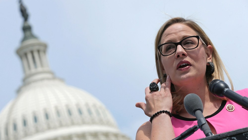 Rep. Kyrsten Sinema (D-AZ) (C) joins a group of bipartisan Congressmen during a news conference outside the U.S. Capitol, May 20, 2014 in Washington, D.C. (Photo by Chip Somodevilla/Getty)