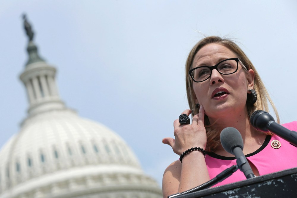 Rep. Kyrsten Sinema (D-AZ) (C) joins a group of bipartisan Congressmen during a news conference outside the U.S. Capitol, May 20, 2014 in Washington, D.C. (Photo by Chip Somodevilla/Getty)