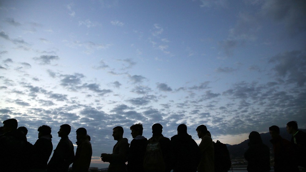 Iraqi, Syrian and Afghan refugees wait in line at dawn for a ferry to Athens after they arrived on the island of Lesbos in a raft from Turkey on Oct. 13, 2015 in Mitilini, Greece. (Photo by Spencer Platt/Getty)