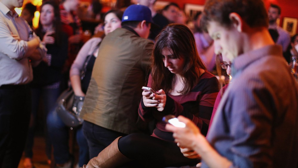 Young adults split their attention between a televised Democratic debate and using their smart phones during a watch party in Washington, DC., Oct. 13, 2015. (Photo by Chip Somodevilla/Getty)