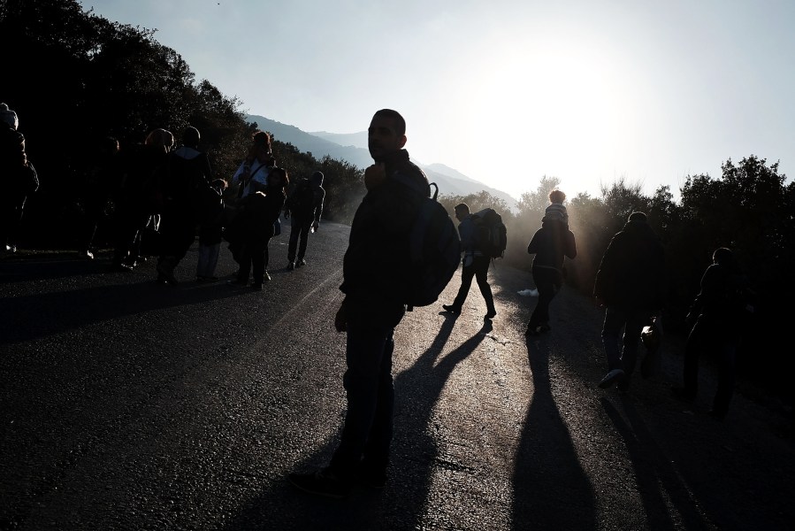 A group of migrants walks to a reception center after arriving by raft from Turkey onto the island of Lesbos on Oct. 19, 2015 in Sikaminias, Greece. (Photo by Spencer Platt/Getty)