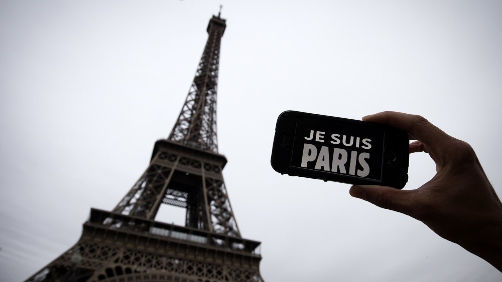 A person holds aloft a smartphone bearing the message "Je Suis Paris" in front of the Eiffel Tour, following a series of attacks on the city in which at least 128 people were killed. (Photo by Joel Saget/AFP/Getty)
