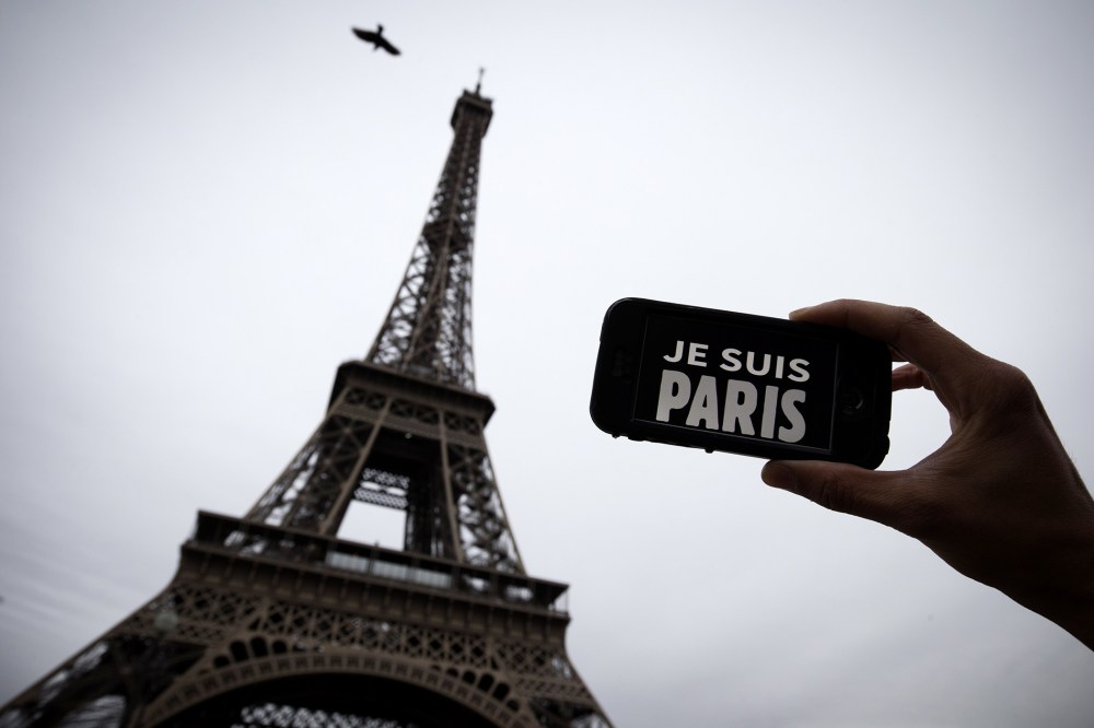A person holds aloft a smartphone bearing the message "Je Suis Paris" in front of the Eiffel Tour, following a series of attacks on the city in which at least 128 people were killed. (Photo by Joel Saget/AFP/Getty)