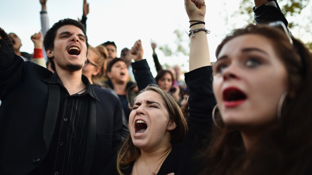 People sing the French national anthem at Place de la Republique as France observes three days of national mourning for the victims of the terror attacks on Nov. 15, 2015 in Paris, France. (Photo by Jeff J Mitchell/Getty)