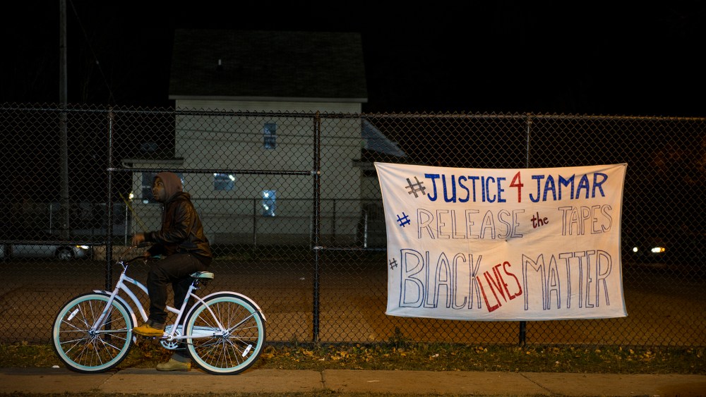 A man pauses on his bike while passing through the protests outside the 4th Precinct police station November 20, 2015 in Minneapolis, Minn. (Photo by Stephen Maturen/Getty)
